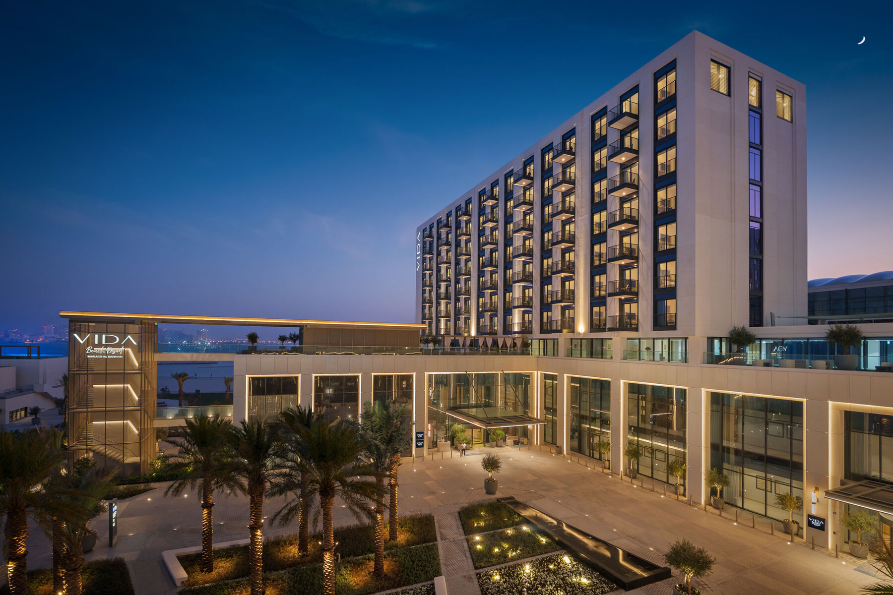 The Vida building and landscaped arrivals courtyard at dusk